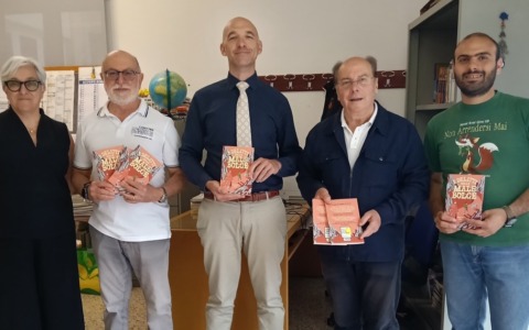 Santa in Giallo consegna i libri agli studenti della scuola media Vittorio G. Rossi