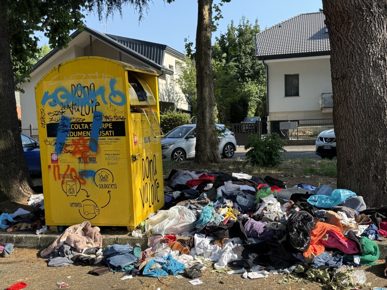 Una montagna di stracci parcheggiata accanto alla metropolitana di Cernusco