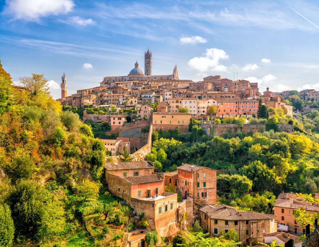 Giornata serena a Siena, nubi residue sui rilievi toscani